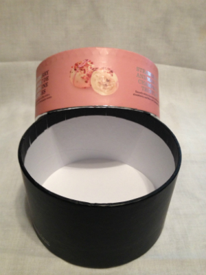 An empty black container with a pink cover